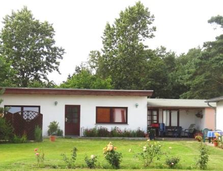 Blick auf die Zimmervermietung Ferienhof Am Kiefernwald mit einem Vierbettzimmer und einer berdachten Sitzflche vor dem Eingang